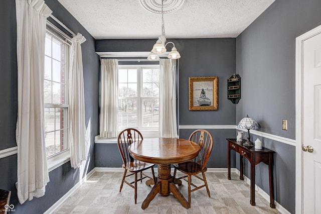 dining area with baseboards and a textured ceiling