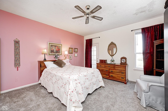 bedroom with carpet, baseboards, and a textured ceiling