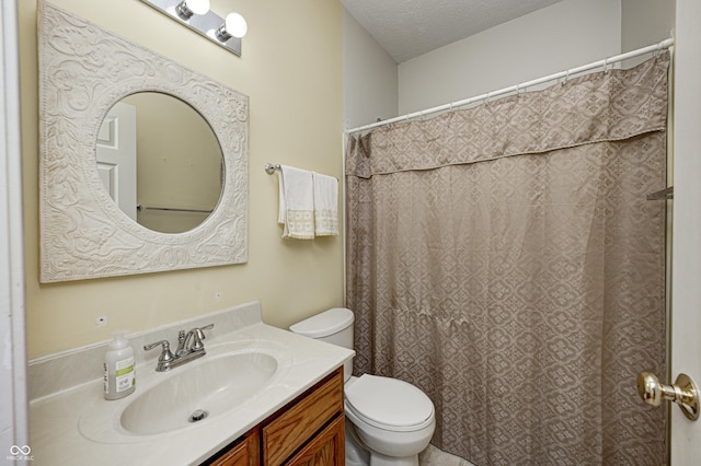 full bathroom featuring a textured ceiling, vanity, and toilet