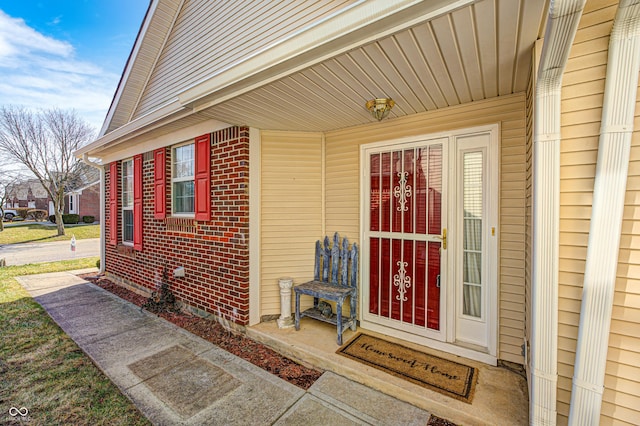 doorway to property featuring brick siding