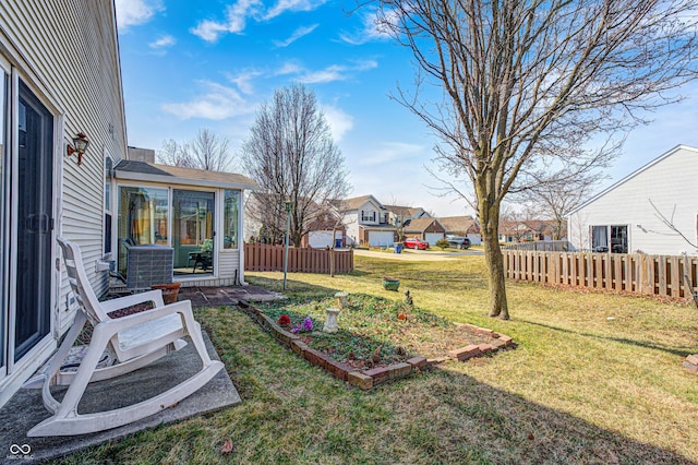 view of yard with a residential view, a sunroom, a vegetable garden, and fence