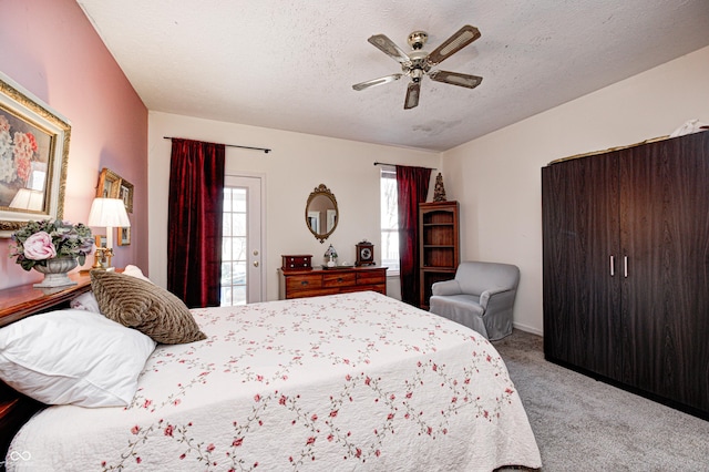 carpeted bedroom featuring ceiling fan, access to exterior, and a textured ceiling