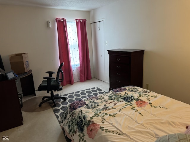 bedroom featuring light colored carpet and a textured ceiling