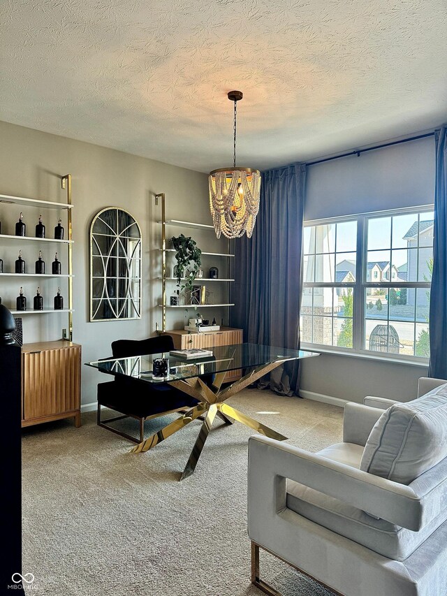 living area featuring an inviting chandelier, baseboards, carpet floors, and a textured ceiling