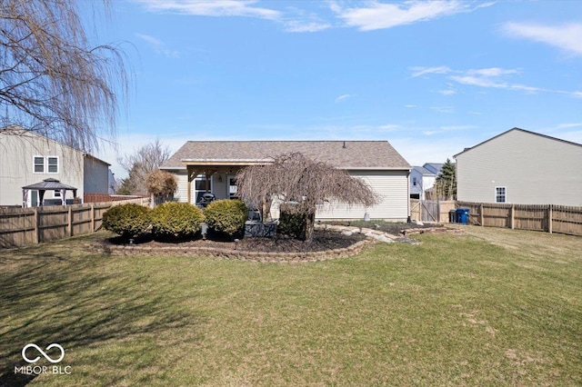 rear view of property with a lawn and a fenced backyard