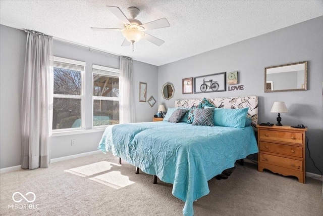 bedroom featuring baseboards, a textured ceiling, a ceiling fan, and carpet floors