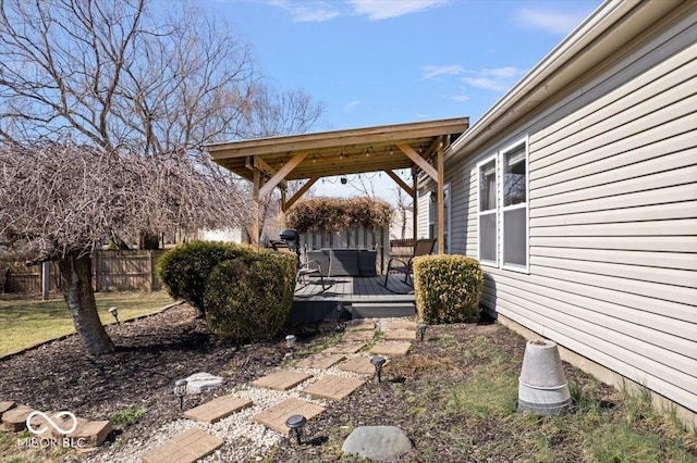 view of yard with a gazebo, a wooden deck, and fence