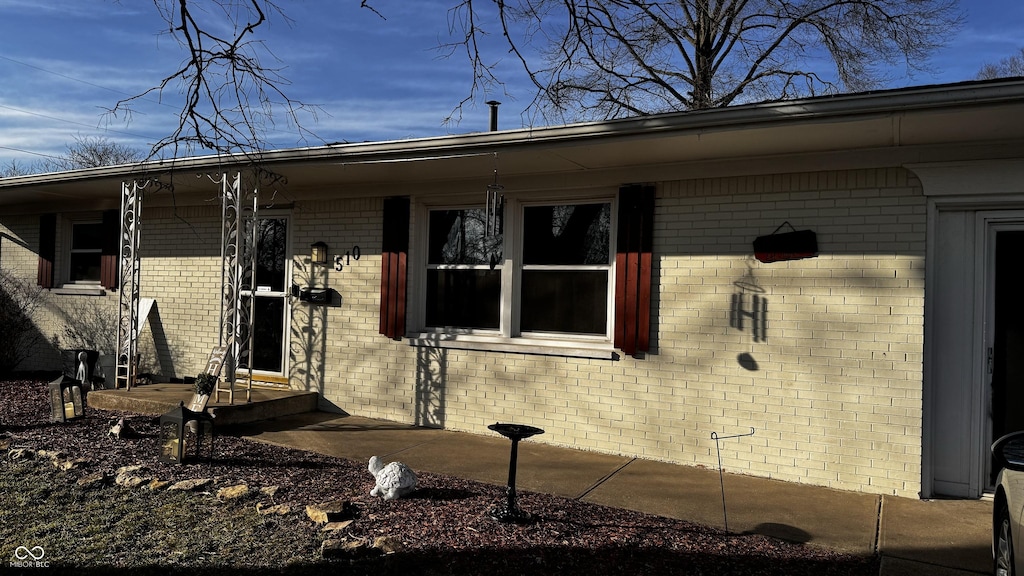 entrance to property featuring brick siding