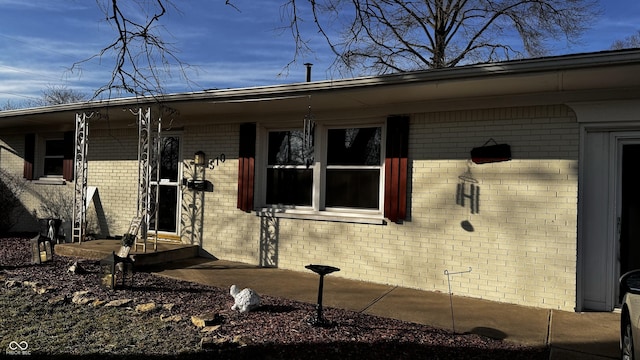 entrance to property featuring brick siding