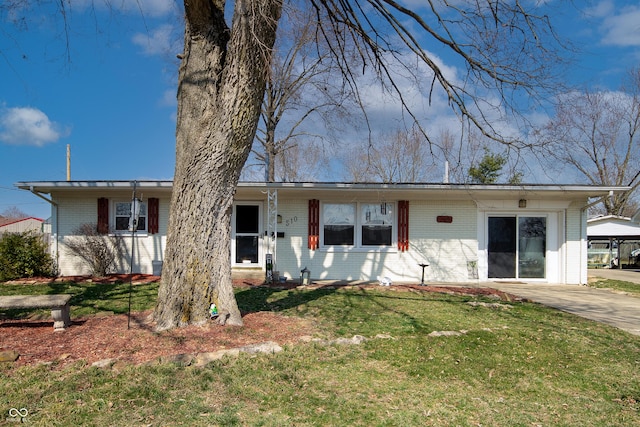 ranch-style house featuring brick siding and a front yard