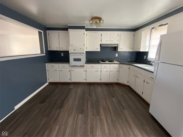 kitchen with dark wood-style floors, white cabinets, a sink, white appliances, and under cabinet range hood