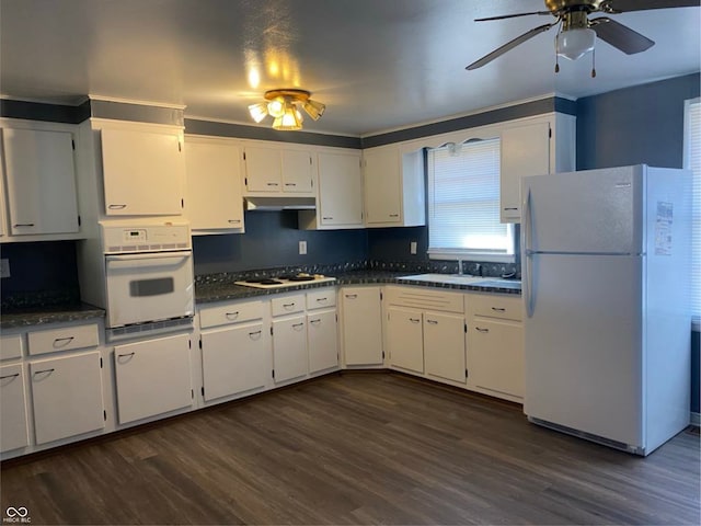 kitchen with dark wood-style floors, dark countertops, white appliances, and under cabinet range hood