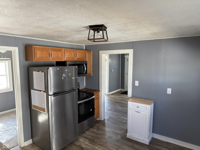 kitchen with dark wood finished floors, stainless steel appliances, brown cabinetry, a textured ceiling, and baseboards