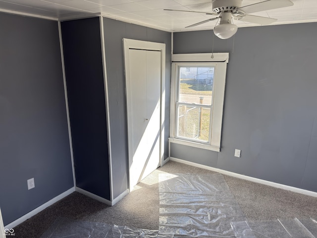 unfurnished bedroom with a ceiling fan, baseboards, and carpet flooring