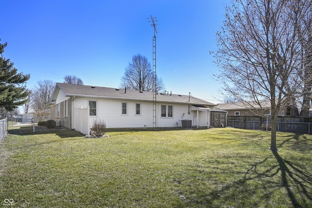 back of property with central air condition unit, a lawn, a fenced backyard, and a gate