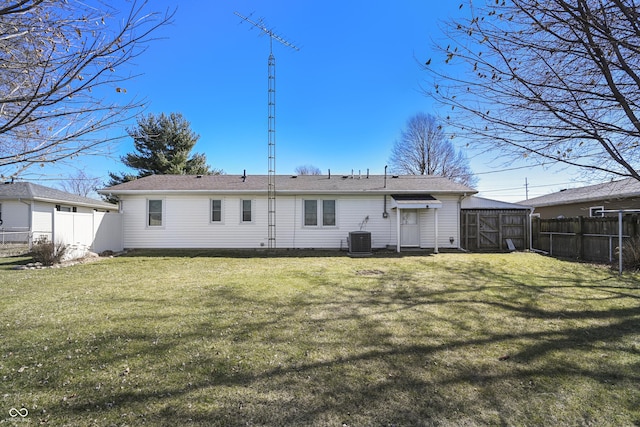 rear view of property featuring central AC unit, a lawn, and a fenced backyard