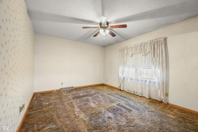 spare room featuring visible vents, carpet floors, a textured ceiling, and baseboards