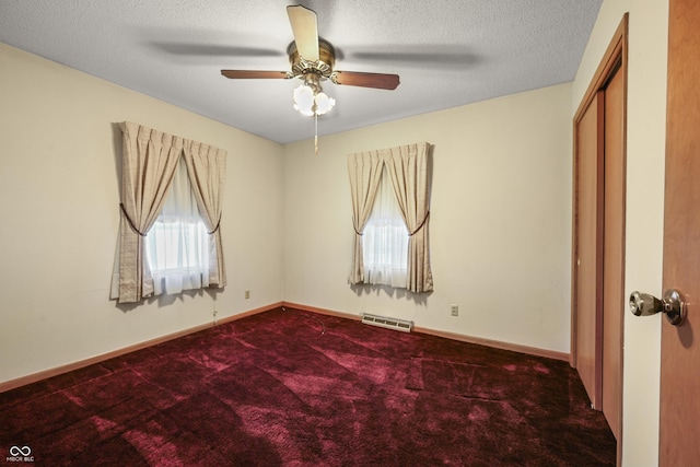 unfurnished bedroom with visible vents, a textured ceiling, carpet flooring, baseboards, and ceiling fan