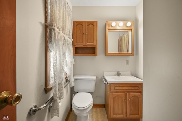 bathroom with vanity, toilet, and baseboards