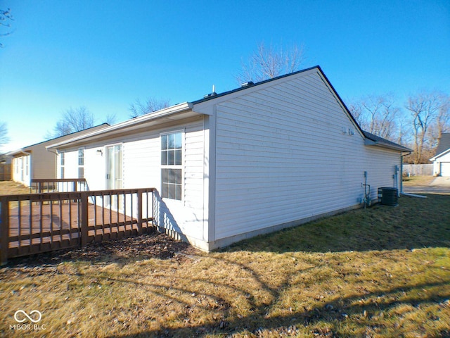 view of property exterior with central AC unit and a yard