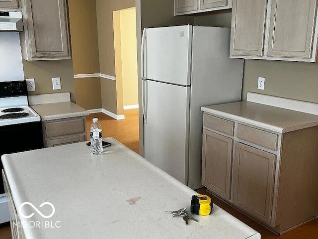 kitchen with light countertops, black range with electric stovetop, ventilation hood, and freestanding refrigerator