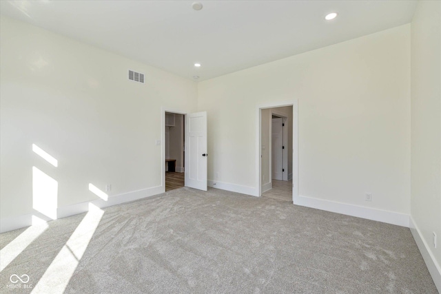 spare room with recessed lighting, baseboards, visible vents, and light carpet