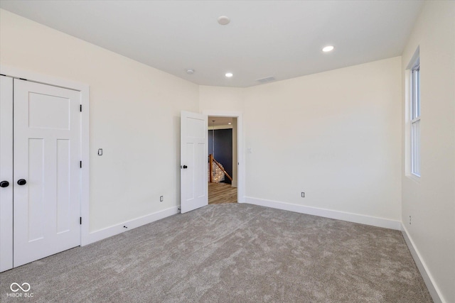 carpeted empty room featuring recessed lighting, visible vents, and baseboards