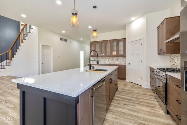 kitchen featuring a sink, recessed lighting, stainless steel appliances, light wood-style floors, and light countertops