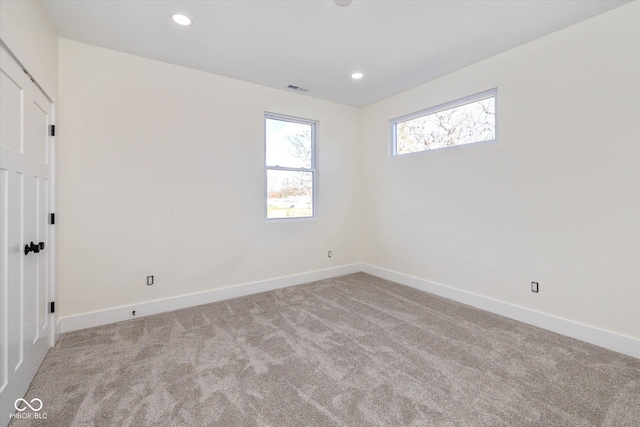 spare room with recessed lighting, visible vents, baseboards, and carpet