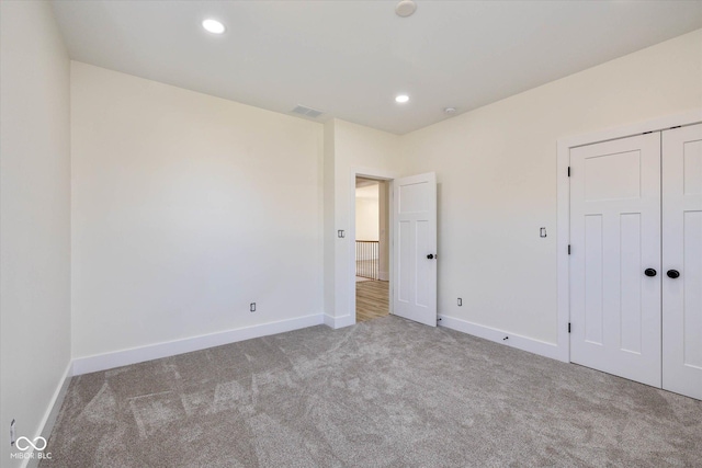 unfurnished bedroom with a closet, recessed lighting, baseboards, and carpet floors