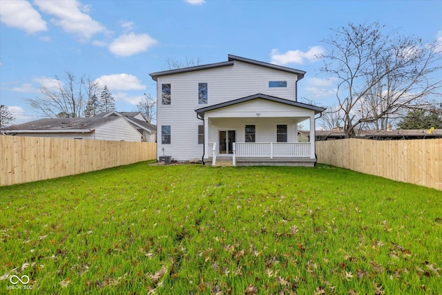 back of house with a fenced backyard, covered porch, and a yard