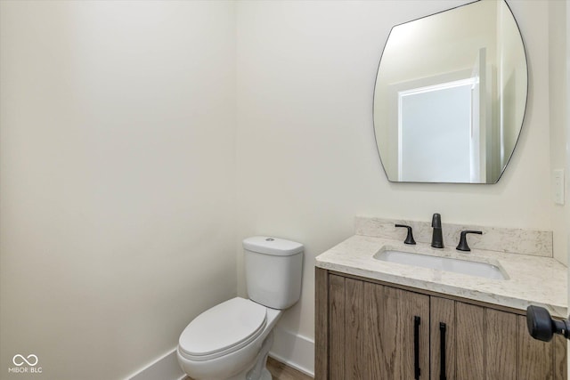 bathroom with vanity, toilet, and baseboards