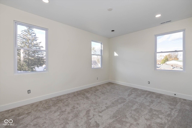 unfurnished room with visible vents, recessed lighting, baseboards, and carpet