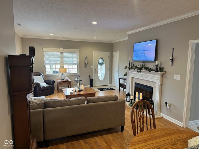 living area with baseboards, a textured ceiling, wood finished floors, and a fireplace