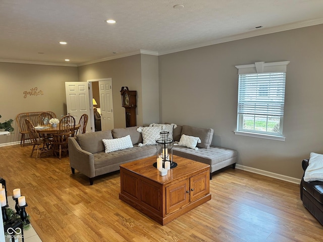 living room featuring visible vents, ornamental molding, recessed lighting, light wood-style floors, and baseboards