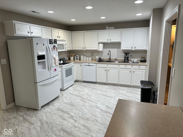 kitchen featuring visible vents, marble finish floor, a sink, white cabinetry, and white appliances