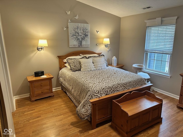 bedroom featuring visible vents, baseboards, and light wood-style floors