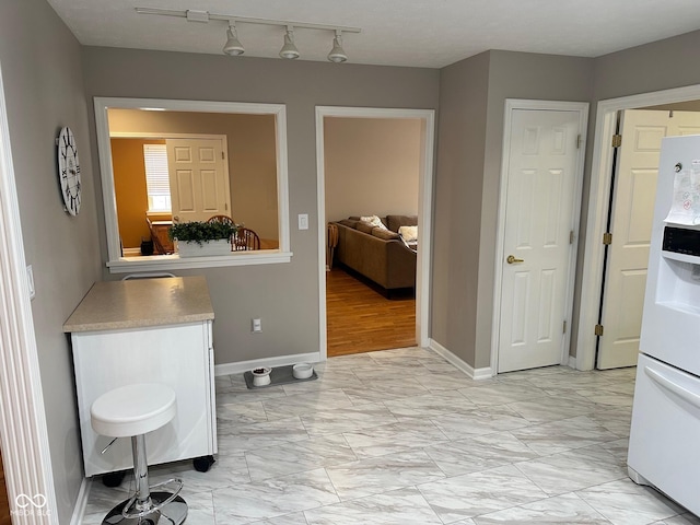 interior space with baseboards and marble finish floor