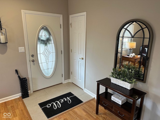 entryway with baseboards and light wood finished floors