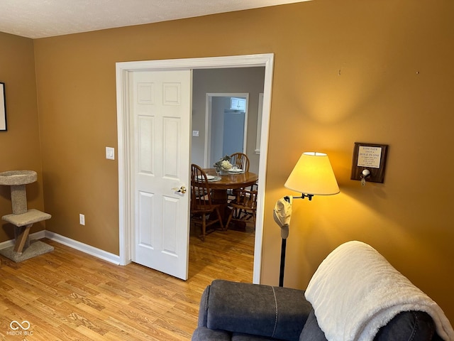 living area with light wood-style flooring and baseboards