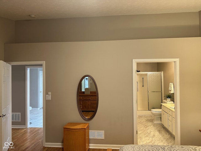 interior space featuring visible vents, baseboards, and connected bathroom