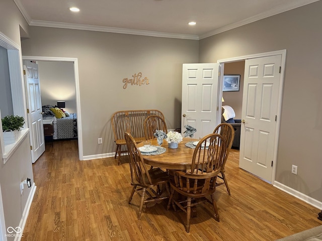 dining area with recessed lighting, crown molding, light wood-type flooring, and baseboards