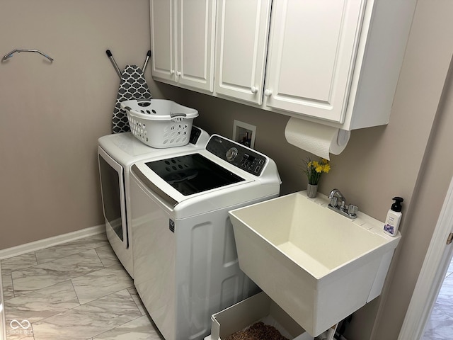 washroom with marble finish floor, a sink, cabinet space, baseboards, and washing machine and clothes dryer