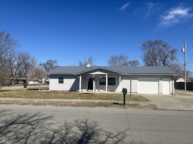 view of front of house with concrete driveway, an attached garage, and metal roof