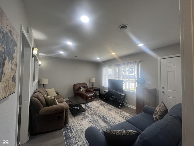 living area featuring visible vents, recessed lighting, baseboards, and wood finished floors