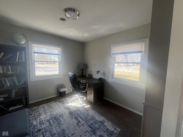 unfurnished office featuring carpet flooring, a healthy amount of sunlight, visible vents, and baseboards