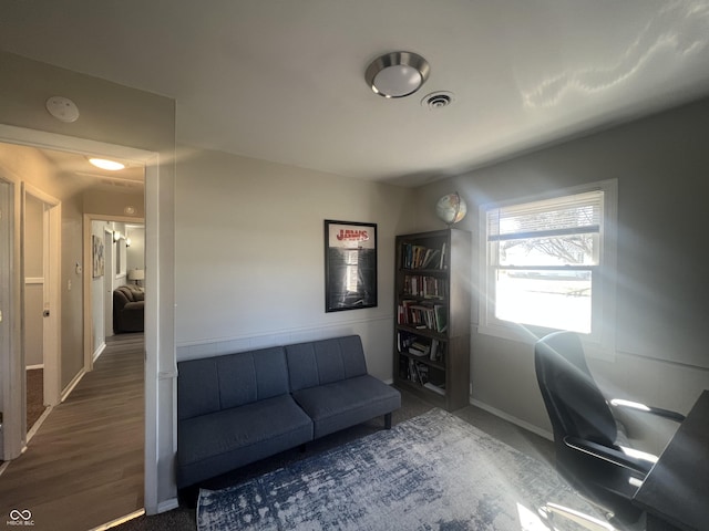 office space featuring baseboards and visible vents