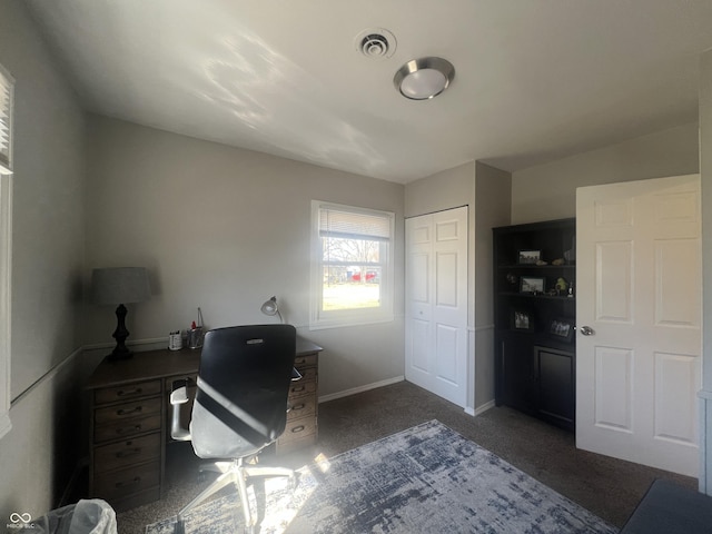 office area featuring visible vents, dark carpet, and baseboards