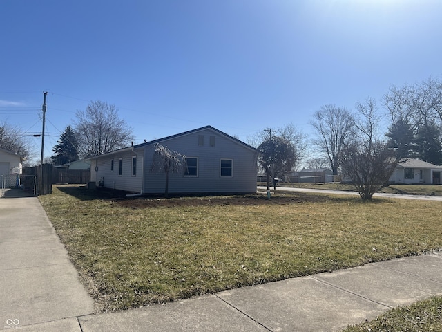 view of property exterior with a yard and fence