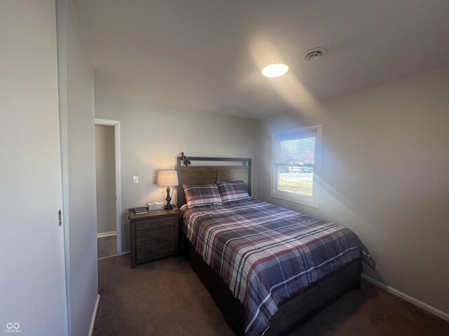 bedroom featuring visible vents, baseboards, and dark colored carpet